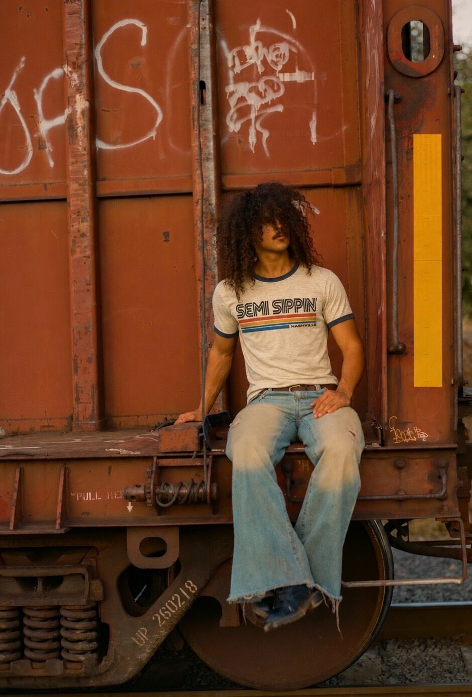 The ringer on a body, late sun, a freight car behind